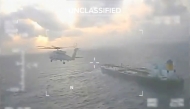 This screen grab taken from a video posted on the X account of US Secretary of Homeland Security Kristi Noem shows a US Coast Guard aircraft flying over a crude oil tanker, last docked in Venezuela, before apprehending it on December 20, 2025. (Photo by Handout / US Secretary of Homeland Security Kristi Noem's X account / AFP) 
