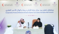 Officials from Dreama and QRCS signing the cooperation protocol.
