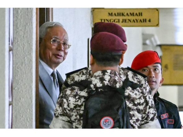 Former prime minister of Malaysia Najib Razak (L) arrives for a court hearing where he seeks to land a ruling allowing him to serve the rest of his six-year sentence under house arrest instead of in the Kajang Prison, at the Kuala Lumpur High Court in Kuala Lumpur on December 22, 2025. (Photo by Mohd Rasfan / AFP)