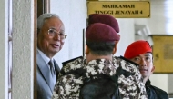 Former prime minister of Malaysia Najib Razak (L) arrives for a court hearing where he seeks to land a ruling allowing him to serve the rest of his six-year sentence under house arrest instead of in the Kajang Prison, at the Kuala Lumpur High Court in Kuala Lumpur on December 22, 2025. (Photo by Mohd Rasfan / AFP)
