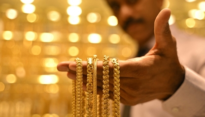 (Files) A salesman displays gold chains at a jewellery store in Bengaluru on September 17, 2025. (Photo by Idrees Mohammed / AFP)