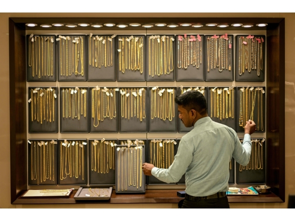 (Files) A salesman arranges gold chains at a jewellery store on July 5, 2025. (Photo by R. Satish Babu / AFP)