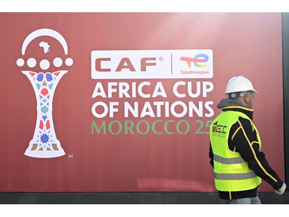 An employee walks past the games' logo outside of the Al-Medina Stadium in Rabat, on December 18, 2025, ahead of the Africa Cup of Nations (AFCON).
