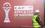 An employee walks past the games' logo outside of the Al-Medina Stadium in Rabat, on December 18, 2025, ahead of the Africa Cup of Nations (AFCON).
