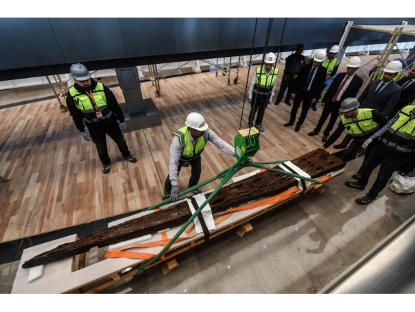 Museum employees install antique wooden planks from King Khufu’s second boat onto a metal structure at the Grand Egyptian Museum in Giza, on the outskirts of Cairo, on December 23, 2025. Photo by Ahmed Hasan / AFP