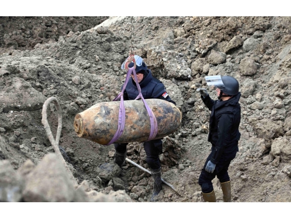 This handout photograph taken on December 28, 2025 and released by Serbia's Ministry of Interior, shows Serbian bomb disposal experts removing a 470-kg World War II aerial bomb, dropped on Nazi-occupied Belgrade in 1944, from a construction site in the Serbian capital. (Photo by Handout / Serbian Ministry of Interior Affairs / AFP) 