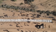This aerial view shows Palestinians burying 54 unidentified bodies in a cemetery in Deir al-Balah, in the central Gaza Strip, on October 22, 2025. (Photo by AFP) / AFP PICTURES OF THE YEAR 2025