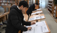 A visitor reads Rodong Sinmun (front), North Korea's top newspaper, at the National Library of Korea in Seoul on January 2, 2026. Photo by Jung Yeon-je / AFP