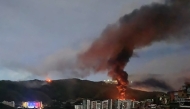 Fire at Fuerte Tiuna, Venezuela's largest military complex, is seen from a distance after a series of explosions in Caracas on January 3, 2026. (Photo by AFP)