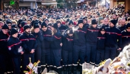 Firefighters from the Municipality of Crans-Montana react as they gather around a makeshift memorial to pay their respects by laying flowers, candles and messages near the Constellation, on January 4, 2026, in Crans-Montana in honour of the victims of the fire that ripped through the venue in the luxury Alpine ski resort on New Year's Eve. Photo by MAXIME SCHMID / AFP