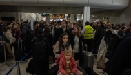 Passengers queue and wait with luggage at a departure hall of Athens' Eleftherios Venizelos international airport in Spata near Athens, on January 4, 2025.  (Photo by Angelos TZORTZINIS / AFP)