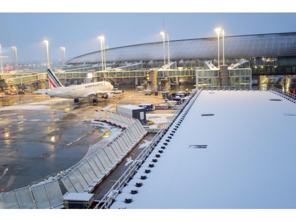 (FILES) This photograph shows an Air France aircraft with snow on the tarmac at the Roissy-Charles de Gaulle airport in Roissy-en-France, in the northern outskirts of Paris, on November 21, 2024. (Photo by Valery HACHE / AFP)