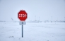 This photograph shows a stop sign near runways as snow blankets the tarmac, causing flight cancellations at Orly Airport, south of Paris on January 7, 2026. Photo by KIRAN RIDLEY / AFP