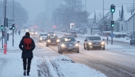 Traffic moves slowly through heavy snowfall in Aalborg, northern Denmark on January 7, 2026. (Photo by Henning Bagger / Ritzau Scanpix / AFP) / Denmark OUT
