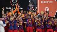 Barcelona's players raise the trophy as they celebrate after winning the Spanish Super Cup final football match between FC Barcelona and Real Madrid at the King Abdullah Stadium in Jeddah on January 11, 2026. (Photo by Fadel SENNA / AFP)