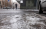 Melting ice is seen on the ground as a commuter makes his way in central Berlin, on January 13, 2026. Photo by Amelie HEIDUK / AFP