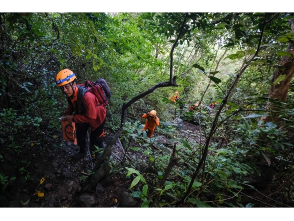 Joint search and rescue teams climb towards the suspected crash site of an Indonesia Air Transport turboprop plane in the Bulusaraung Mountains, South Sulawesi, Indonesia, January 18, 2026. (Photo by Muchtamir / AFP)