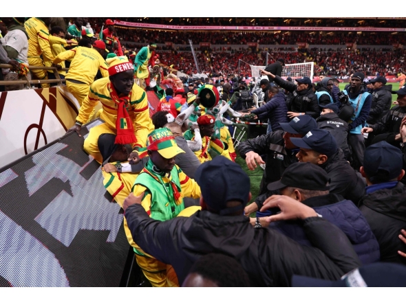 Fans scuffle with security personnel as they storm the field after a penalty decision against Senegal during the Africa Cup of Nations (CAN) final football match between Senegal and Morocco at the Prince Moulay Abdellah Stadium in Rabat on January 18, 2026. (Photo by Franck FIFE / AFP)