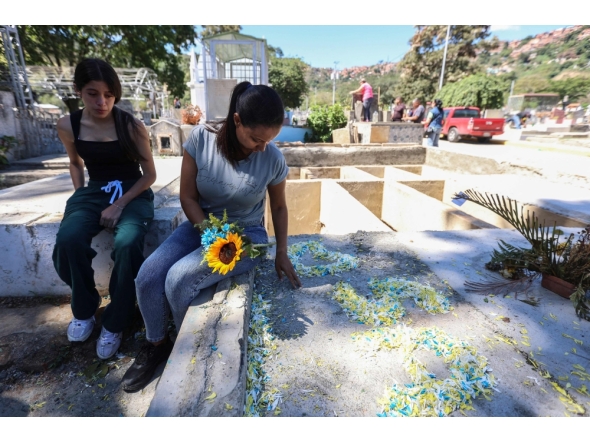 Natividad Martinez (R), mother of private Saul Pereira, visits his grave at the General Cemetery of the South in Caracas on January 18, 2026. (Photo by Pedro Mattey / AFP)