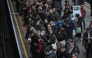 Commuters wait for a train on the platform at Earls Court Tube station in London on January 15, 2026. Photo by JUSTIN TALLIS / AFP