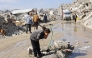 Displaced Palestinians live amongst the rubble and debris of homes and businesses destroyed by the Israeli military in over two years of military strikes on the Gaza Strip enclave, drinks water from a stand pipe, in Jabalia refugee camp, in the northern Gaza Strip on January 17, 2026. Photo by OMAR AL-QATTAA / AFP

