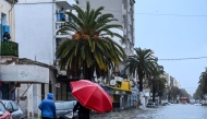 Residents make their way through flood waters, in La Goulette near the capital Tunis, on Januray 20, 2026. (Photo by FethiI Belaid / AFP)
 