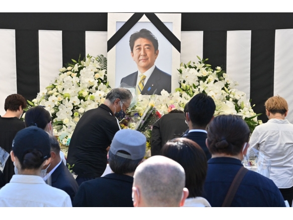 This photo taken on September 27, 2022 shows people offering their respects to former Japanese prime minister Shinzo Abe outside the Nippon Budokan in Tokyo, ahead of his state funeral later in the day. Photo by Yuichi YAMAZAKI / AFP