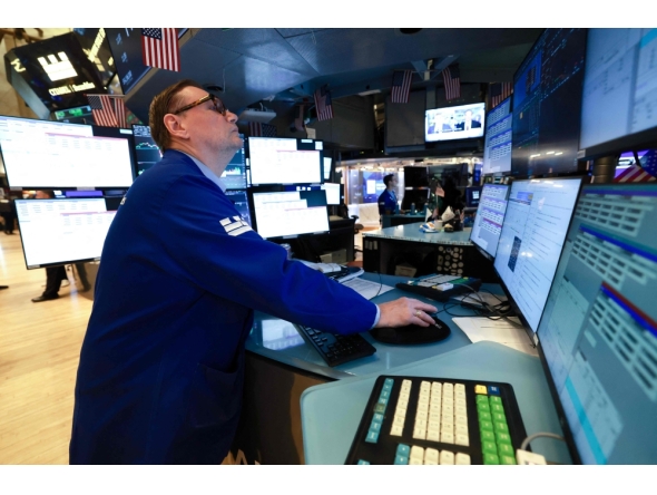 A trader works on the floor of the New York Stock Exchange (NYSE) at the opening bell in New York on January 23, 2026. (Photo by Timothy A. Clary / AFP)