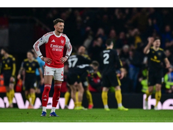 Arsenal's English defender #04 Ben White (L) reacts after Manchester United's Brazilian striker #10 Matheus Cunha scored his team's third goal in the 87th minute during the English Premier League football match between Arsenal and Manchester United at the Emirates Stadium in London on January 25, 2026. (Photo by Ben STANSALL / AFP)
