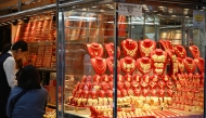 A customer (2nd L) visits a shop selling gold in Hong Kong on January 26, 2026. (Photo by Peter Parks / AFP)