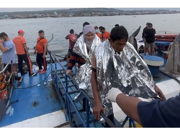 This screen grab from video footage taken and received on January 26, 2026 from Governor Mujiv Hataman shows rescuers assisting survivors of the sunken MV Trisha Kerstin 3 at a port in Isabela, Basilan province. (Photo by Handout / Governor Mujiv Hataman / AFP)