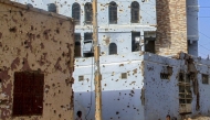 Children photographed near houses damaged with bullets in Omdurman. AFP file photo.