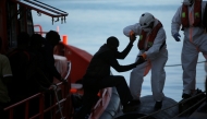 File photo: A migrant, part of a group intercepted aboard a dinghy off the coast in the Mediterranean Sea, is helped by a rescuer after arriving on a rescue boat at the port of Malaga, Spain June 22, 2018. REUTERS/Jon Nazca