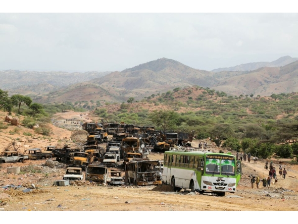 Villagers return from a market to Yechila town in south central Tigray walking past scores of burned vehicles, in Tigray, Ethiopia, on July 10, 2021. File Photo / Reuters