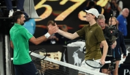 Serbia's Novak Djokovic greets Italy's Jannik Sinner after winning their men's singles semi-final match on day thirteen of the Australian Open tennis tournament in Melbourne. (Photo by DavidD Gray / AFP) 