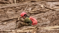 A rescuer rests as they search for victims buried by a landslide in Pasirlangu village in Cisarua, Bandung, West Java, on January 26, 2026. Photo by Timur Matahari / AFP
