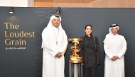 Chairman of Media City Qatar H E Sheikh Dr. Abdulla bin Ali Al-Thani (left), CEO of Media City Qatar Hamad Omar A Al-Mannai (right), and artist Yasamin Shaikhi with her winning artwork 'The Loudest Grain'.
