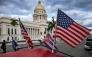 Two US flags and a Cuban flag flutter on the roof of a tricycle in front of the Capitolio in Havana on February 3, 2026. (Photo by YAMIL LAGE / AFP)