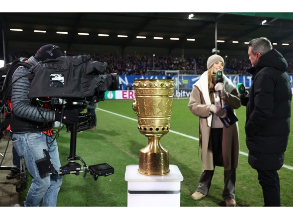 Media representatives are seen by the German Cup trophy displayed prior to the start of the German Cup (DFB-Pokal) quartefinal football match between Holstein Kiel and VfB Stuttgart in Kiel, northern Germany on February 4, 2026. (Photo by Ibrahim OT / AFP) 