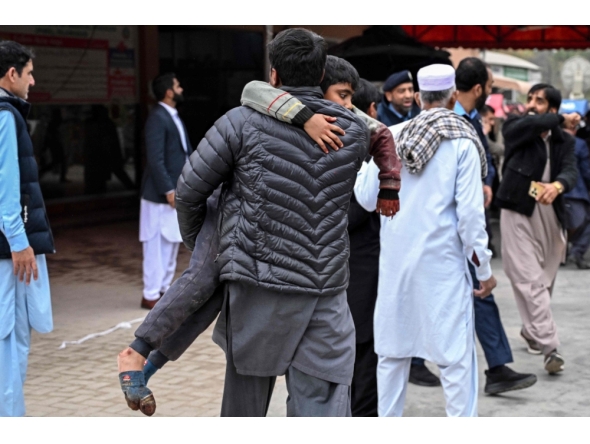 A man carries an injured boy to a hospital following an explosion at a mosque in Islamabad on February 6, 2026. (Photo by Aamir Qureshi / AFP)