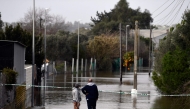 Two people observe a flooded area at Las Pachecas settlement in Jerez, southern Spain, on February 5, 2026, amid Storm Leonardo. (Photo by Cristina Quicler / AFP)