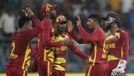 West Indies' Gudakesh Motie celebrates with teammates after taking the wicket of England's captain Harry Brook during the 2026 ICC Men's T20 Cricket World Cup group stage match between England and West Indies at the Wankhede Stadium in Mumbai on February 11, 2026. (Photo by Indranil MUKHERJEE / AFP)

