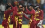 West Indies' Gudakesh Motie celebrates with teammates after taking the wicket of England's captain Harry Brook during the 2026 ICC Men's T20 Cricket World Cup group stage match between England and West Indies at the Wankhede Stadium in Mumbai on February 11, 2026. (Photo by Indranil MUKHERJEE / AFP)
