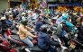 Motorists cross railway tracks on the motorbikes after a train passed on the popular train street in Hanoi on February 13, 2026. (Photo by Amaury Paul / AFP)