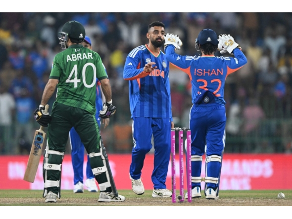 India's Varun Chakravarthy (C) celebrates with wicketkeeper Ishan Kishan after taking the wicket of Pakistan's Abrar Ahmed during the 2026 ICC Men's T20 Cricket World Cup group stage match between India and Pakistan at the R Premadasa Stadium in Colombo on February 15, 2026. (Photo by Ishara S.KODIKARA / AFP)