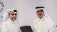 Director General of Qatar Press Center Sadiq Al-Amari and Executive Director of the Middle East Council on Global Affairs Khalid Al-Jaber exchanging documents after signing the agreement.