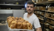 French volunteer baker Loic Nervi holds a basket of freshly baked bread in his mobile bakery in Borodyanka, Kyiv region on February 19, 2026. (Photo by Genya Savilov / AFP)