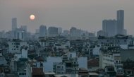 A general view shows the sun setting over the skyline in the old quarter of Hanoi on February 20, 2026. (Photo by Amaury Paul / AFP)
