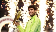 Spain's Carlos Alcaraz celebrates with the trophy after winning his men痴 singles final match against France's Arthur Fils at the Qatar Open tennis tournament in Doha on February 21, 2026. (Photo by Karim JAAFAR / AFP)

