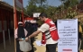 A Qatar Red Crescent Society representative distributing agricultural kits to female-headed households in Bangladesh.